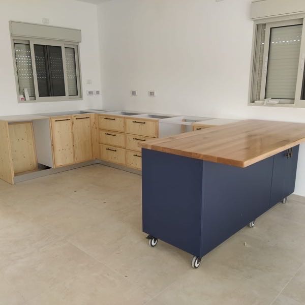 מטבח בגוון ירוק אפור עם ארון גבוה סביב פתח מעבר
